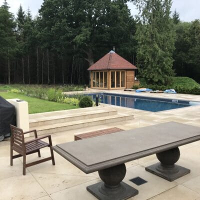Patio area with view across pool towards gazebo garden design Sussex Kent